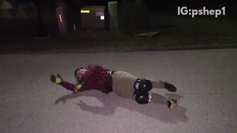 Plaid helmet guy falls off skateboard at night and hits head on sidewalk