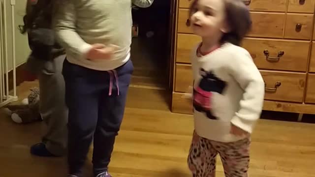 Three kids spin around on wood floor one falls down