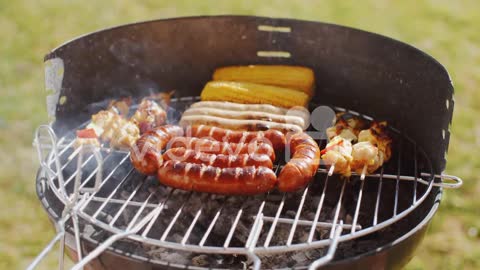 Sausages corncobs and kebabs grilling on a BBQ