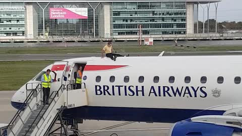Man Sits on top of Plane at London City Airport