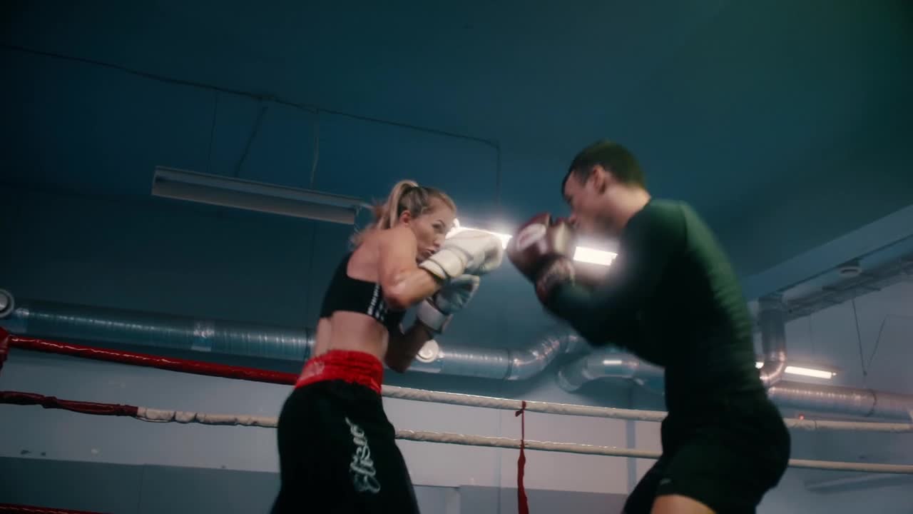 A Man and Woman Competing Inside the Boxing Ring