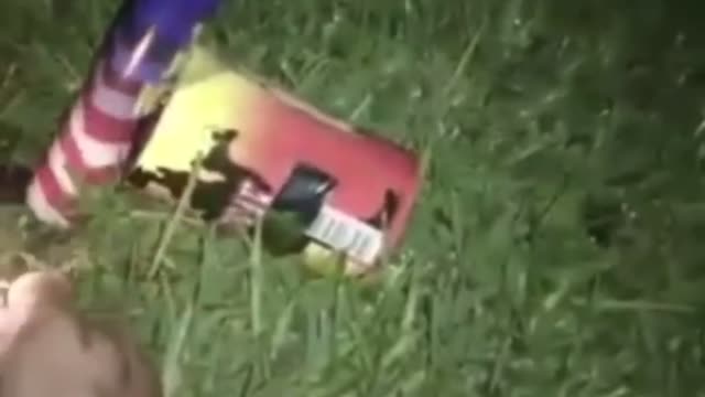 Guy lights firework on grass