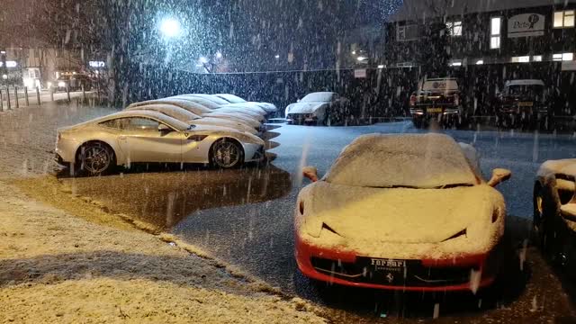 Ferrari Sports Car and many luxury cars Parked While Snowing.