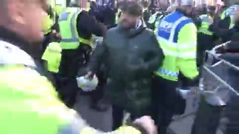 officers restrain a man on the floor as another sticks the boot in