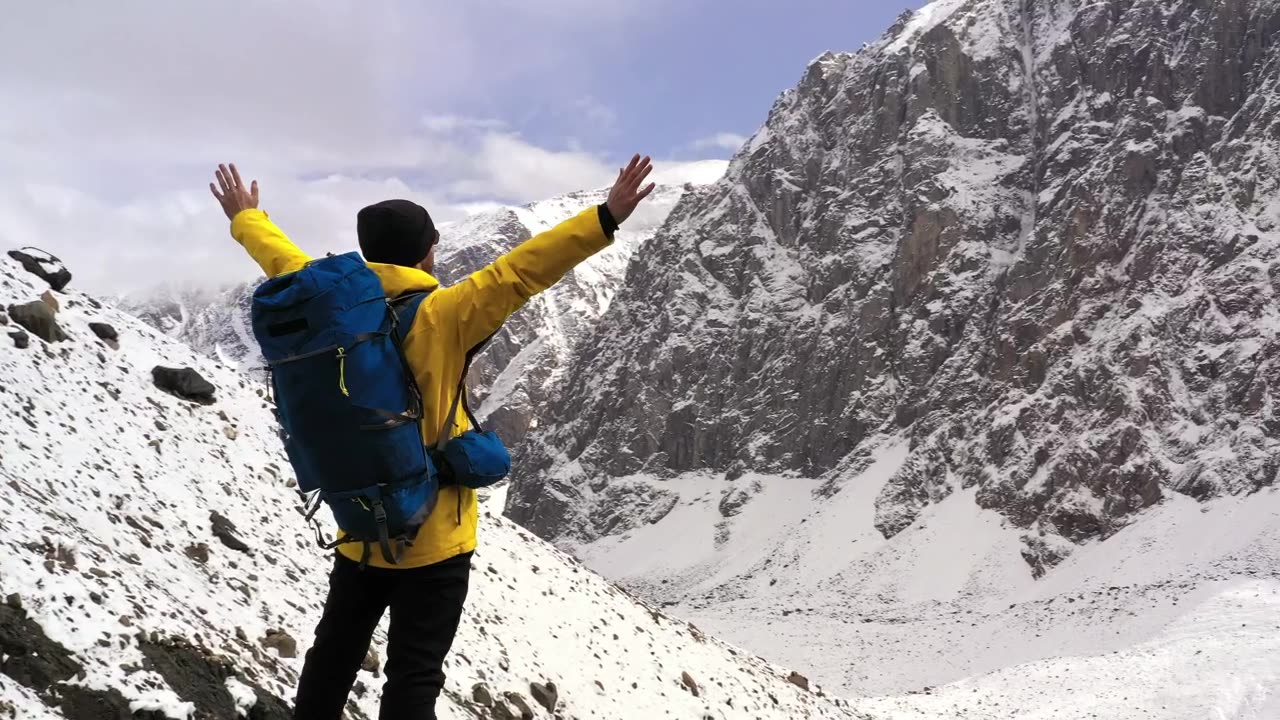 Courageous hiker spreads arms over mountain summit