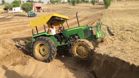 John Deer 5310 climbing a sand bank