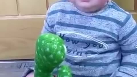 Cute babies playing with dancing cactus.