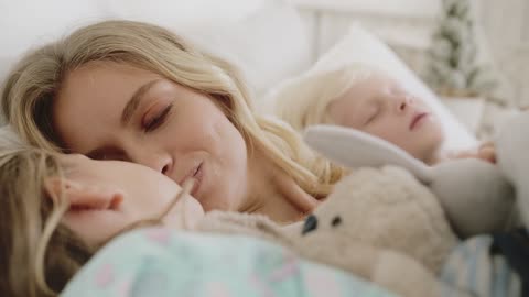 A Mother Loving Moments With Her Two Children Lying In