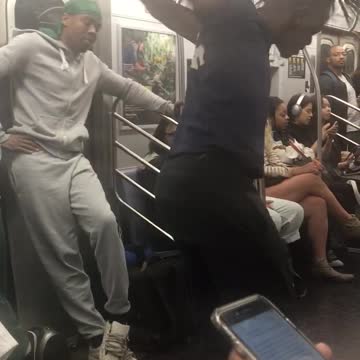 Guy dark blue shirt dancing on pole music subway