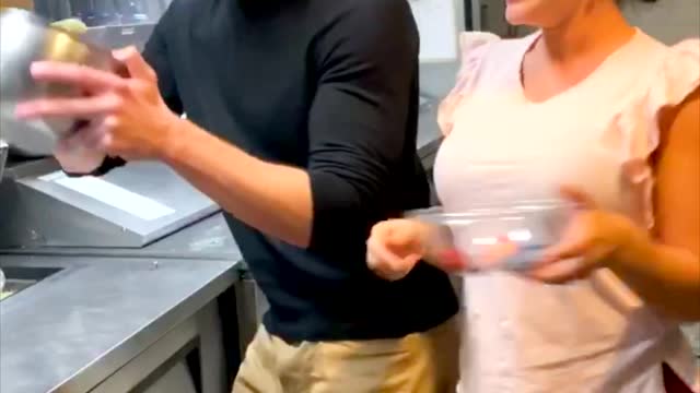 Woman trying to tease Man and making food