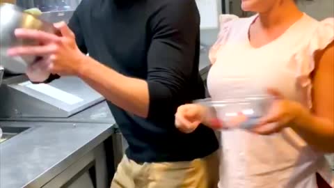 Woman trying to tease Man and making food