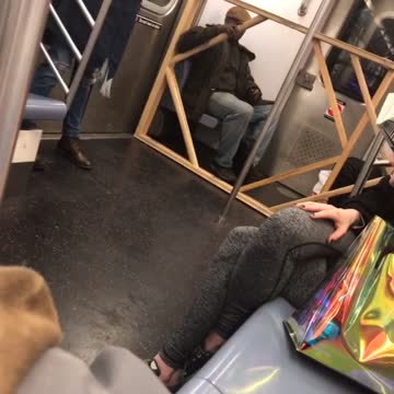 Man brings a big wooden rectangle frame with him on subway train