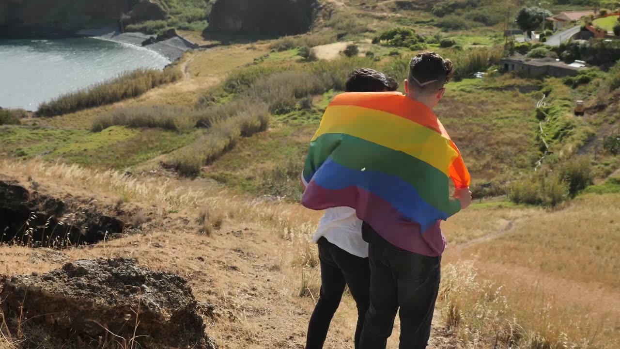 Two guys wearing the rainbow flag