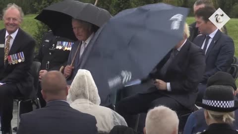 Boris Johnson struggles with umbrella at police memorial unveiling