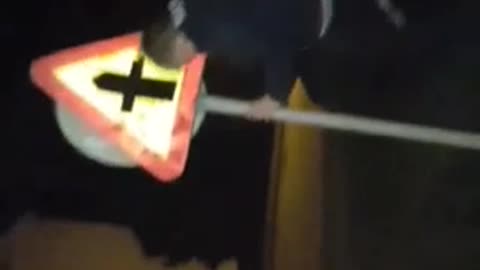 Man in track suit to and smack his head onto a crossing sign at night