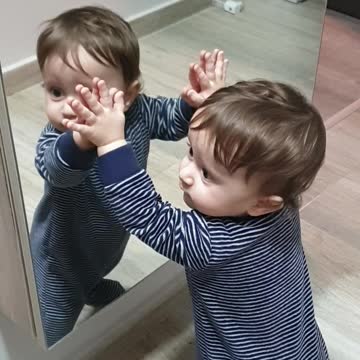 Sweet Baby Kisses His Reflection In The Mirror