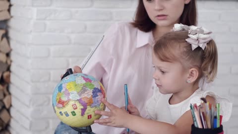 A Mother Teaching Her Daughter About The Globe