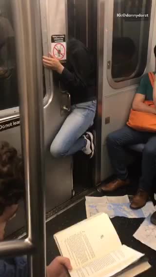 Subway moving with guy in black jacket and jeans in between subway door