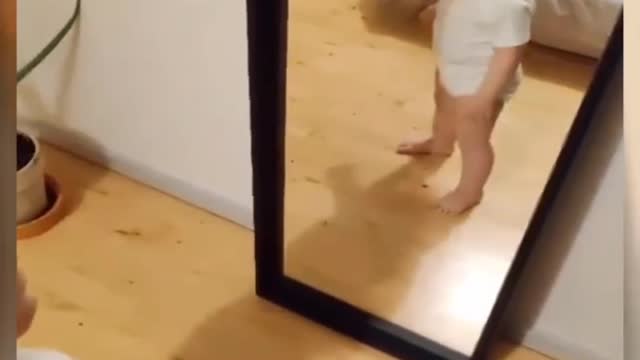 Laughing baby in front of mirror