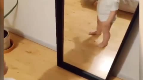 Laughing baby in front of mirror