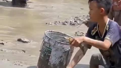 Country children help their parents catch fish.