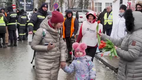 Romanians greet refugees with International Women's Day flowers