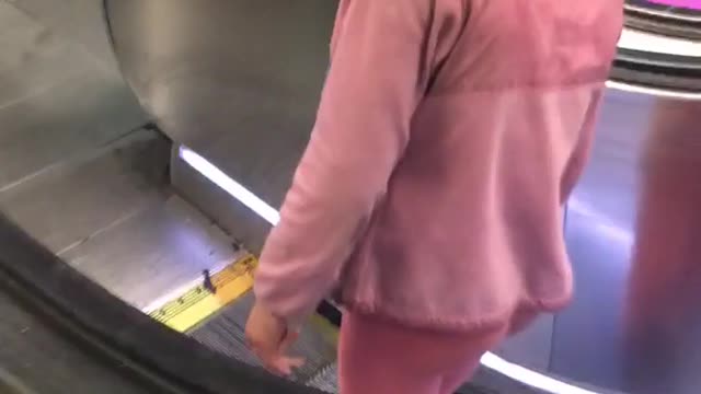 Pink shirt guy can barely stand on escalator