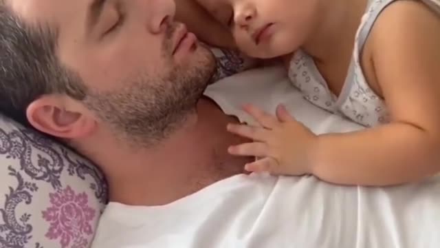 Little girl cuddling the dady when sleeping