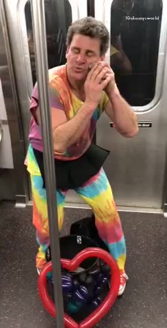 Man in tie dye outfit performs on subway