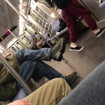 Red track pants headphones guy dances up and down subway car