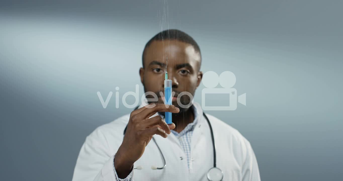 Close Up Of The Young Man Physician Or Intern Holding A Syringe With A Needle And Withdrawing Fluid