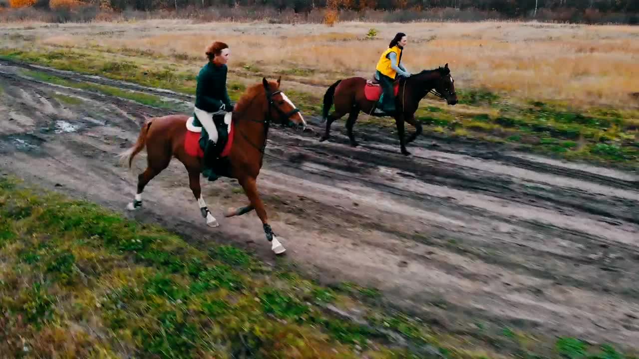 Two women galloping in the field