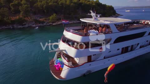 Swimmers and partiers jump off a large yacht or boat in the Adriatic Sea near Croatia