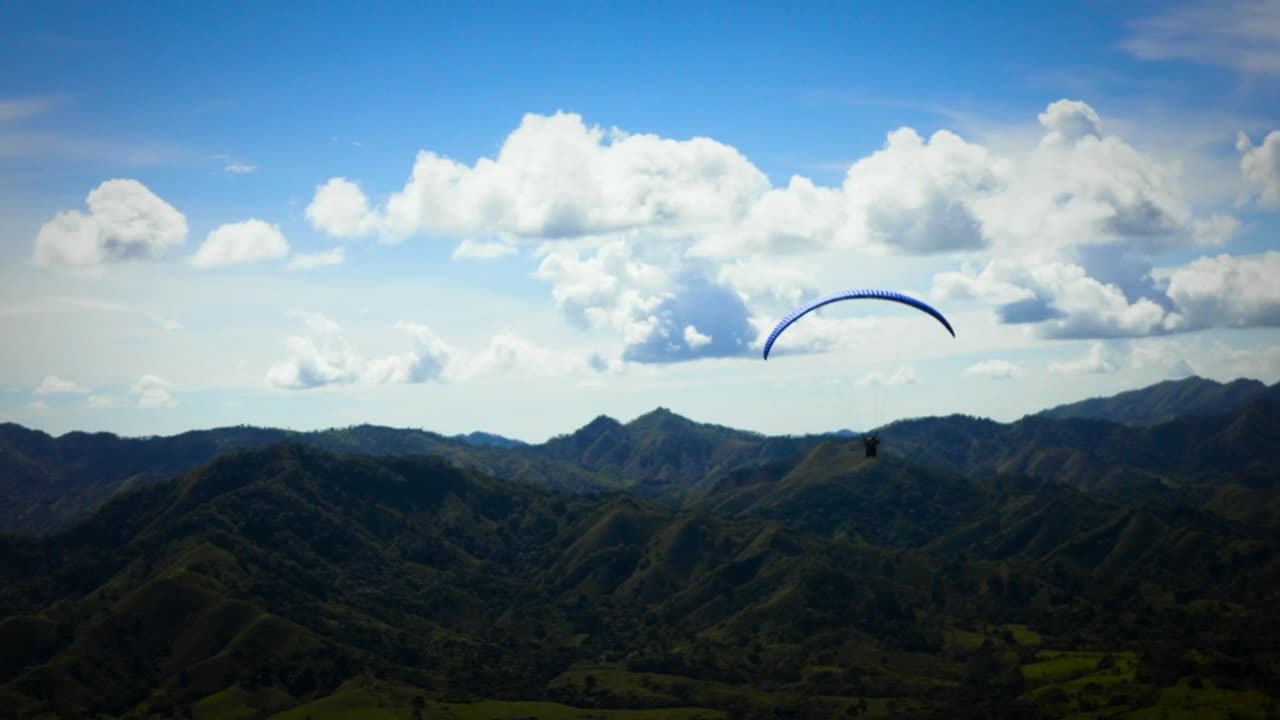 skydiver flying over a mountain-range