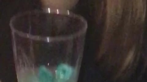 Music girl puts blue toy in drink