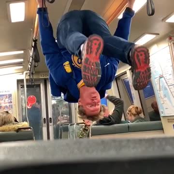 Drunk man with golden state warriors shirt holds onto subway handrails and does backflip