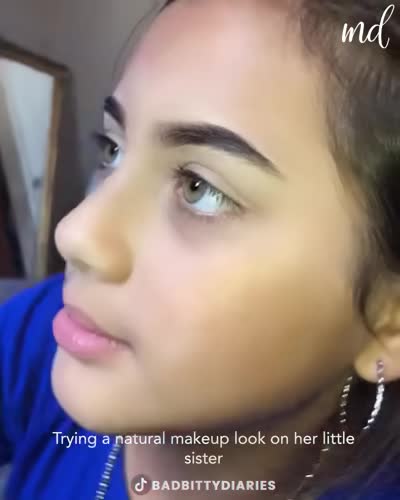 Trying a natural makeup look on her little sister