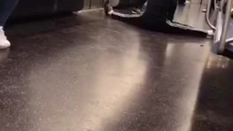 Man in blue beanie and does splits on subway