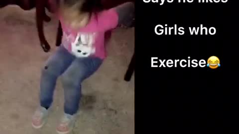 Pink shirt little girl exercises on carpet