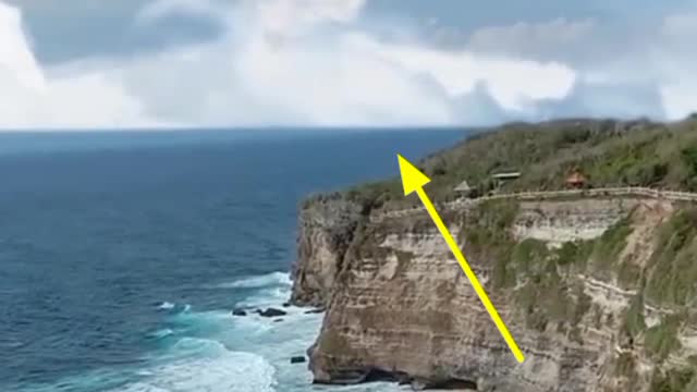 The appearance of a clud in the shape of a woman face above the cliffs of the coast of Bali'