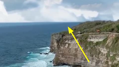 The appearance of a clud in the shape of a woman face above the cliffs of the coast of Bali'