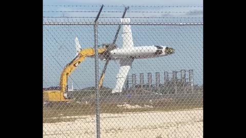 a man in a excavator takes a jet and flies with it like a toy