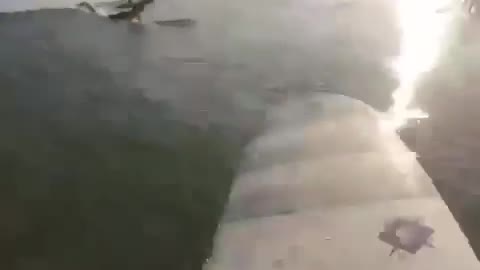 Guy on surfboard gets hit by wave and falls in water