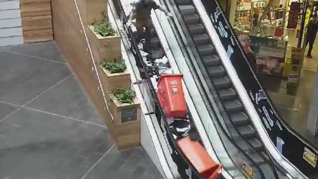 Man Makes a Huge Paper Mess Going Up Escalator