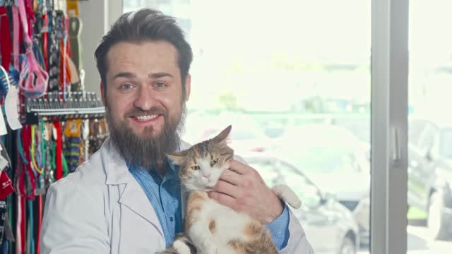 Friendly vet smiling to the camera, holding cute grumpy cat