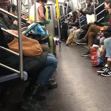 Man makes balloon animal hearts on subway train, gives one to woman recording