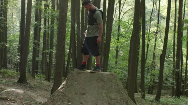 A Mountain Biker Standing on a Ramp at a Track