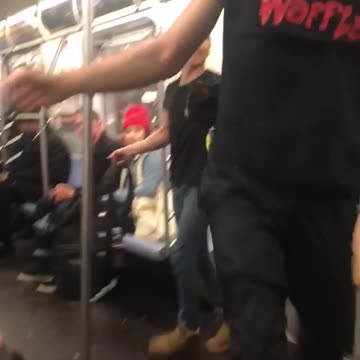 Guy spins upside down on subway train handrail