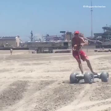 Guy red swim shorts riding skateboard sand beach scooter