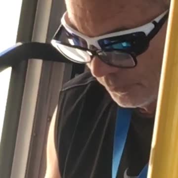 Balding guy subway reading with glasses over sunglasses